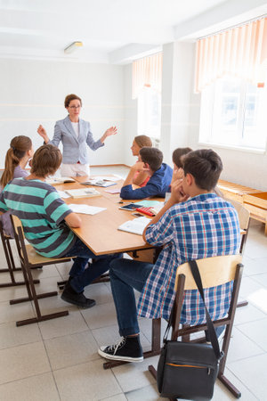 group of students learning with teacher in the classroom at school