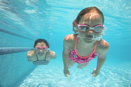 Two teenager girs l having fun with bubbles in the pooll.Underwater photo.の写真素材