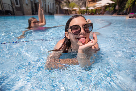 teenager gir having fun in swimming pool on resortの写真素材