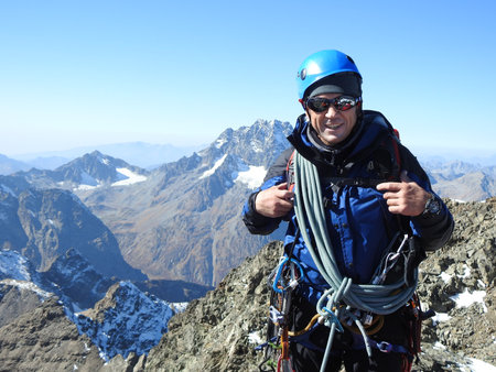 mountainee rclimbing on the top of a mountain in the background of the landscape of snowy mountainsの写真素材