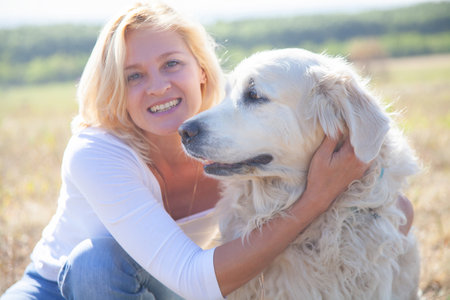 Middle aged woman with big white dogの写真素材