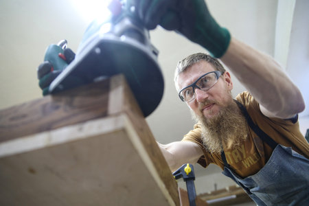 professional carpenter works in his workshop on wooden products.の写真素材