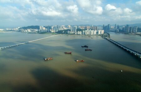 Macau boats on water at Chinese buildings on Taipaの写真素材