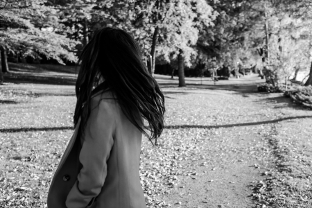 Woman at the end of a road looking backの写真素材