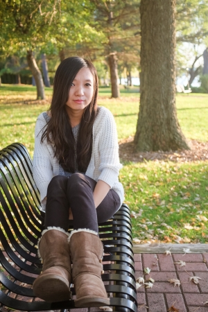 lonely young woman sitting on a steel benchの写真素材