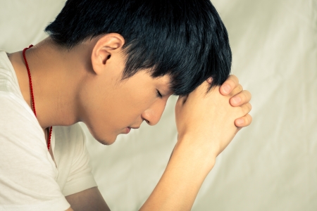 Young man supporting his head looking depressed, in fashion tone and backgroundの写真素材
