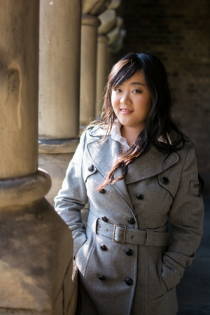 Young Asian woman standing near pillar structureの写真素材