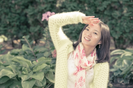 Young woman shielding herself from the bright sun with one handの写真素材