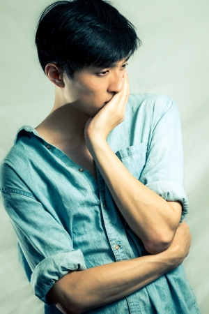 Studio fashion pose by a handsome young male model, with fashion tone and backgroundの写真素材