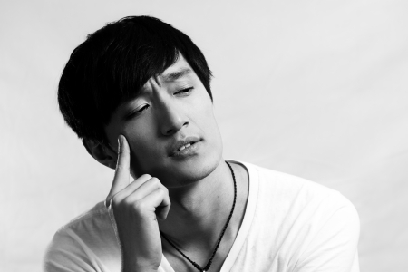 Portrait of handsome young man looking deep in thought, black and white styleの写真素材