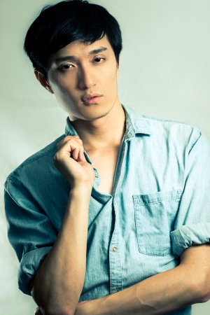 Studio fashion pose by a handsome young male model, with fashion tone and backgroundの写真素材