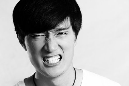 Portrait of young man looking angry and yelling, black and white styleの写真素材