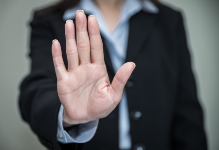 Professional woman in business suit shaking one hand and denying on grey background の写真素材