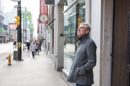 TORONTO, ON, CANADA - OCTOBER 30:  Lonely old man standing alone on Young street and listening to music, in Toronto Canada on October 30, 2013のeditorial素材