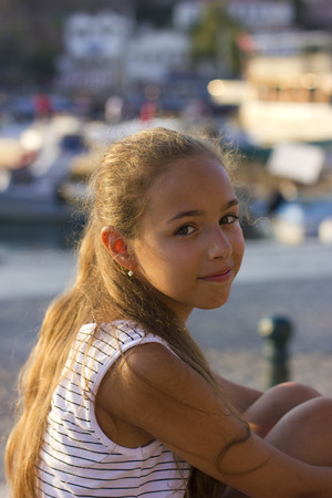 Young girl sitting at the harborの写真素材