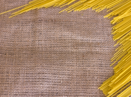 Raw spaghetti on the brown old sackclothの写真素材