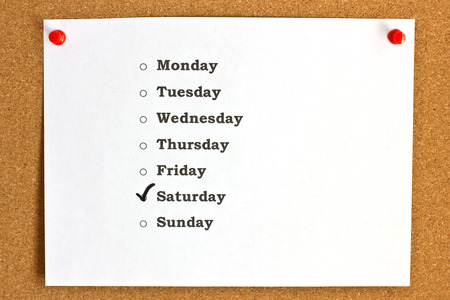 Sheet with days of a week and marked Saturday, pinned to the cork board