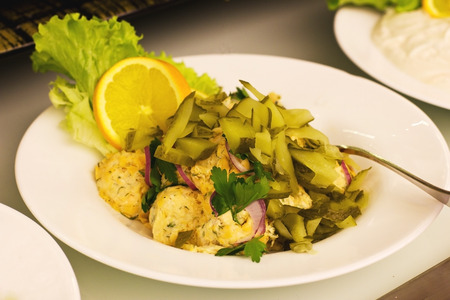 Vegetable salad with the mayonnaise, pickled cucumbers, decorated with parsley