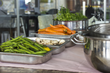 Fresh vegetables in a metal trays in the restaurant. Carrots, green string beans, champignonsの写真素材