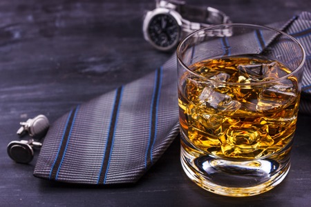 Male concept for father's day. Tie, watches, cufflinks and glass of whiskey with iceの写真素材