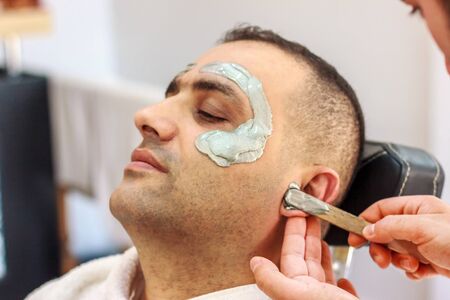 Male face waxing. Barber removes hair by shugaring from face of turkish man.の写真素材