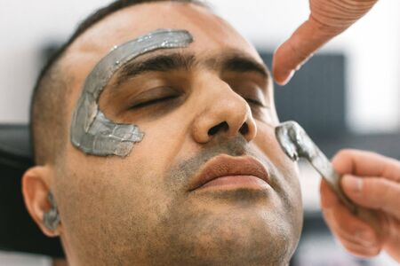 Male face waxing. Barber removes hair by shugaring from face of turkish man.の写真素材