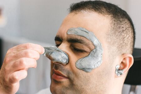 Male face waxing. Barber removes hair by shugaring from face of turkish man.の写真素材