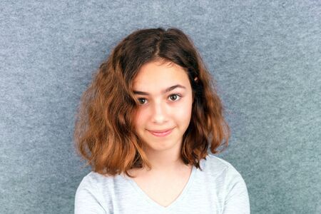 Portrait of pretty curly teenager girl looking at camera
