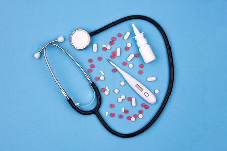 Fighting the virus - phonendoscope, thermometer and medicine. Capsules and pills, spray for nose on...