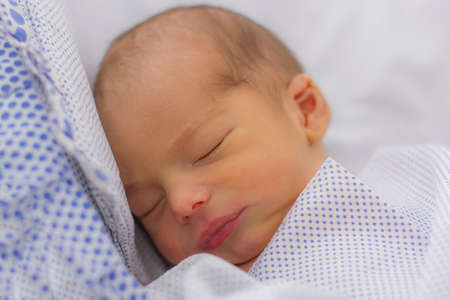 Sweet calm newborn baby sleeping on the bed