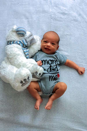 Happy little baby with smiling face. Cute infant with bear toy