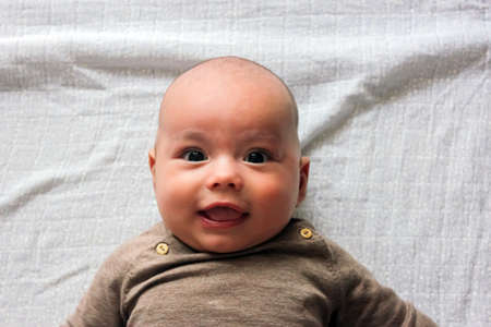 Portrait of cute baby close-up. Sweet little infant looks to cameraの写真素材