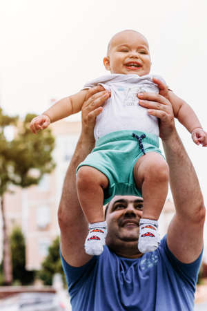 Father playing with his baby. Dad throws son to the air.の写真素材