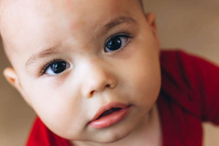 Portrait of cute baby close-up. Sweet little infant looks to cameraの写真素材