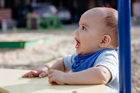 Cute happy smiling baby boy at playground outdoorsの写真素材