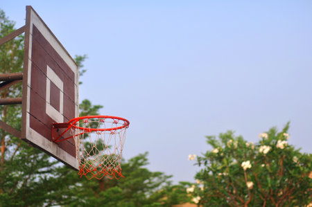 Old wooden basketball hoop has a natural background and sky.の写真素材