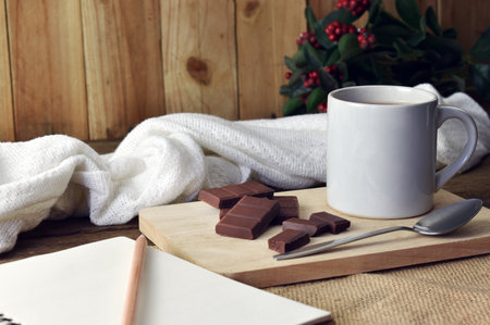 A hot chocolate mug is placed on a wooden tray with a wooden plank wall background.の写真素材