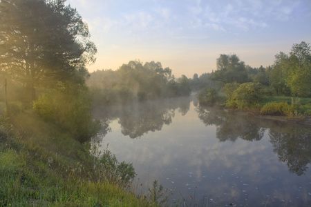 Morning on the river in a fog and sun raysの写真素材