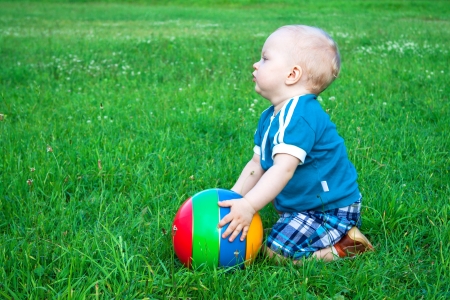 the small child plays on a green summer meadowの写真素材