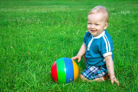 the small child plays on a green summer meadowの写真素材