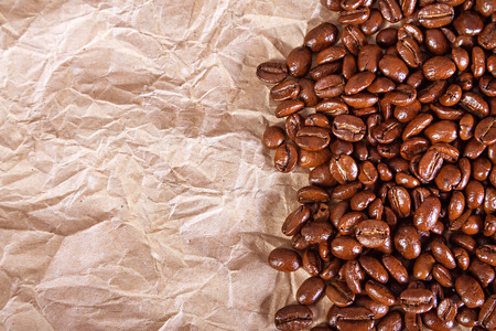 the fried beans of coffee on a crushed paper  backgroundの写真素材