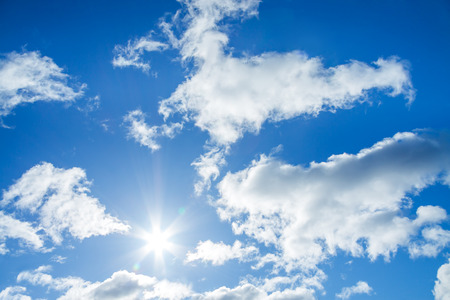 the blue sky with white clouds and the sunの写真素材