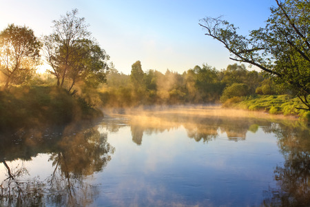 rural landscape with sunrise over the river and fogの写真素材