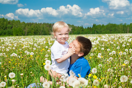 two children plays on a green meadowの写真素材