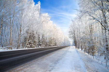 winter landscape with the road the forest and the blue skyの写真素材