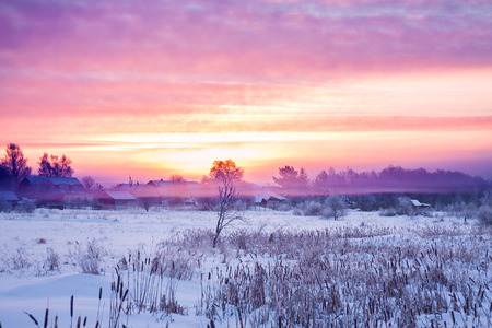 beautiful winter rural landscape with sunrise and fogの写真素材
