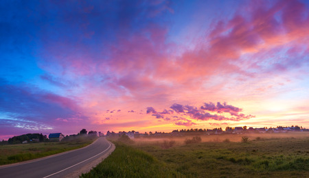 beautiful rural landscape with sunrise,blue sky and clouds panorama. panoramic view with sunset, village and road.の写真素材