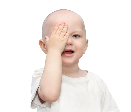 hurt a small child is crying,wiping tears with the hand,isolated on white background. little boy tears wipesの写真素材