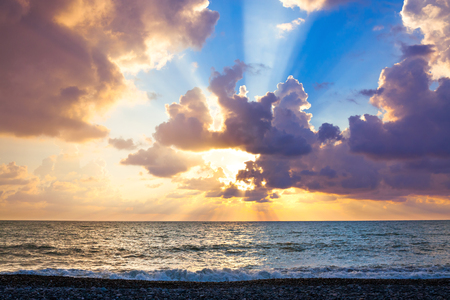 Beautiful sea landscape with a sunset. Evening purple sky with clouds over ocean. Sea surf with wavesの写真素材