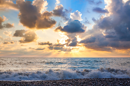 Beautiful sea landscape with a sunset. Evening purple sky with clouds over ocean. Sea surf with wavesの写真素材